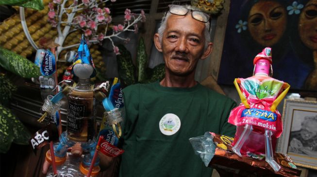 Seniman Pontianak Harry Eko Rifanto memperlihatkan dua mainan yang terbuat dari limbah plastik di Kian Gallery Mustang di Gang Belibis, Pontianak, Kalimantan Barat, Jumat (1/4/2022) malam. [ANTARA FOTO/Jessica Helena Wuysang/foc]