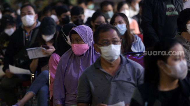 Warga mengantre untuk menerima suntikkan vaksin COVID-19 booster di kawasan Gelora Bung Karno (GBK), Jakarta, Minggu (3/4/2022). [Suara.com/Angga Budhiyanto]