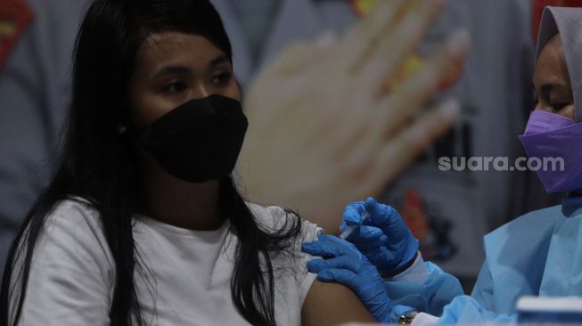 Warga menerima suntikkan vaksin Covid-19 booster di kawasan Gelora Bung Karno (GBK), Jakarta, Minggu (3/4/2022). [Suara.com/Angga Budhiyanto]