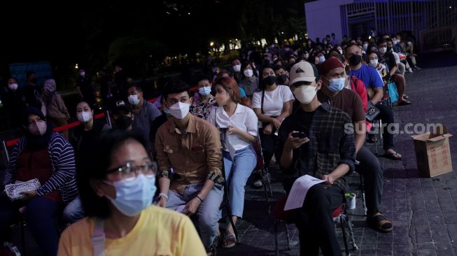 Warga mengantre untuk menerima suntikkan vaksin COVID-19 booster di kawasan Gelora Bung Karno (GBK), Jakarta, Minggu (3/4/2022). [Suara.com/Angga Budhiyanto]