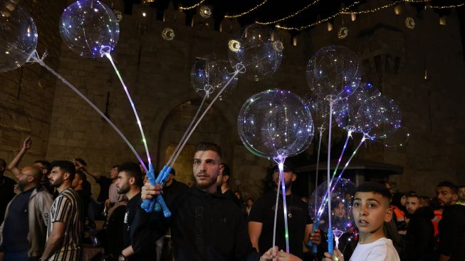 Warga Palestina menjual balon di luar gerbang Damaskus di Kota Tua Yerusalem, Sabtu (2/4/2022). [Menahem KAHANA / AFP]
