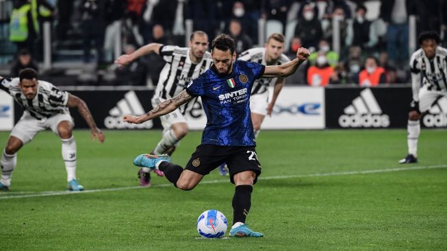 Gelandang Inter Milan Hakan Calhanoglu melakukan tendangan penalti keduanya saat pertandingan sepak bola Serie A Italia antara Juventus dan Inter di Stadion Allianz, Turin, Italia, Minggu (3/4/2022). [Filippo MONTEFORTE / AFP]