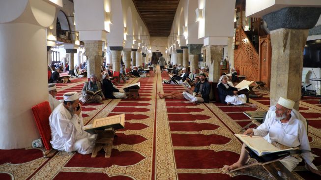 Umat Muslim membaca Alquran di Masjid Al-Kabir, Sana'a, Yaman, Sabtu (2/4/2022). [MOHAMMED HUWAIS / AFP]