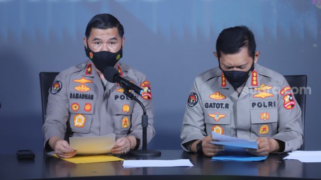 Kepala Biro Penerangan Masyarakat (Karopenmas) Brigjen Pol Ahmad Ramadhani didampingi Kepala Bagian Penerangan Umum (Kapagpenum) Kombes Pol Gatot Repli Handoko menunjukkan berkas penetapan Daftar Pencarian Orang (DPO) atas nama Putra Wibowo saat konferensi pers di Gedung Divisi Humas Polri, Jakarta Selatan, Senin (4/4/2022). [Suara.com/Alfian Winanto]