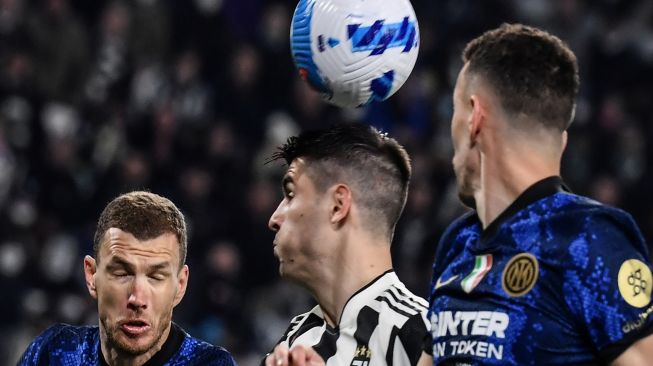 (Dari kiri) Penyerang Inter Milan Edin Dzeko, penyerang Juventus Alvaro Morata beradu sundulan saat pertandingan sepak bola Serie A Italia antara Juventus dan Inter di Stadion Allianz, Turin, Italia, Minggu (3/4/2022). [Filippo MONTEFORTE / AFP]