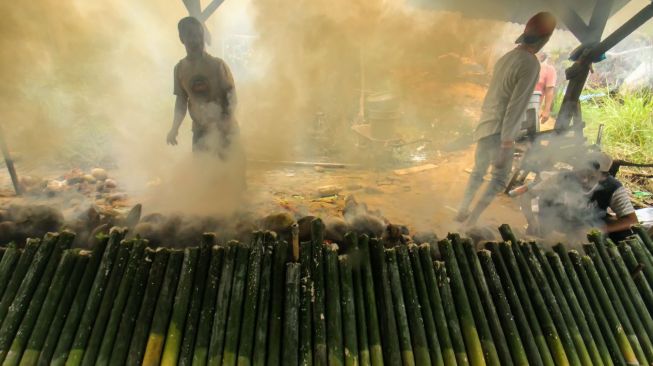Pembuat leumang membakar leumang bambu di Desa Blang Rayeuk, Lhokseumawe, Aceh, Minggu (3/4/2022). [ANTARA FOTO/Rahmad/YU]