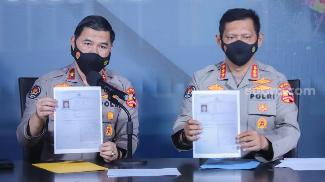 Kepala Biro Penerangan Masyarakat (Karopenmas) Brigjen Pol Ahmad Ramadhani didampingi Kepala Bagian Penerangan Umum (Kapagpenum) Kombes Pol Gatot Repli Handoko menunjukkan berkas penetapan Daftar Pencarian Orang (DPO) atas nama Putra Wibowo saat konferensi pers di Gedung Divisi Humas Polri, Jakarta Selatan, Senin (4/4/2022). [Suara.com/Alfian Winanto]