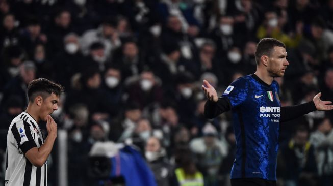 Pemain depan Juventus Paulo Dybala (kiri) dan pemain depan Inter Milan Edin Dzeko saat pertandingan sepak bola Serie A Italia antara Juventus dan Inter di Stadion Allianz, Turin, Italia, Minggu (3/4/2022). [Filippo MONTEFORTE / AFP]