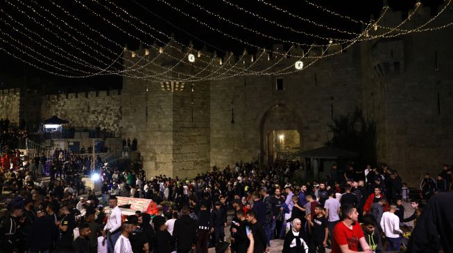 Warga Palestina berkumpul di luar gerbang Damaskus di Kota Tua Yerusalem, Sabtu (2/4/2022). [Menahem KAHANA / AFP] 