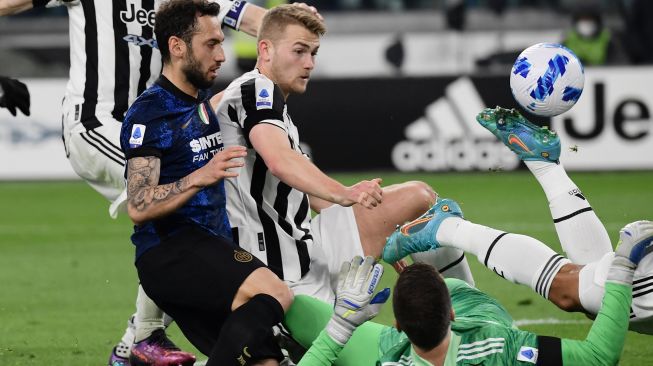 (Dari kiri) Gelandang Inter Milan Hakan Calhanoglu, Bek Juventus Matthijs De Ligt, Kiper Juventus Wojciech Szczesny dan bek Juventus Danilo (kanan) bertabrakan setelah Szczesny menepis tendangan penalti pertama Calhanoglu saat pertandingan sepak bola Serie A Italia antara Juventus dan Inter di Stadion Allianz, Turin, Italia, Minggu (3/4/2022). [Filippo MONTEFORTE / AFP]