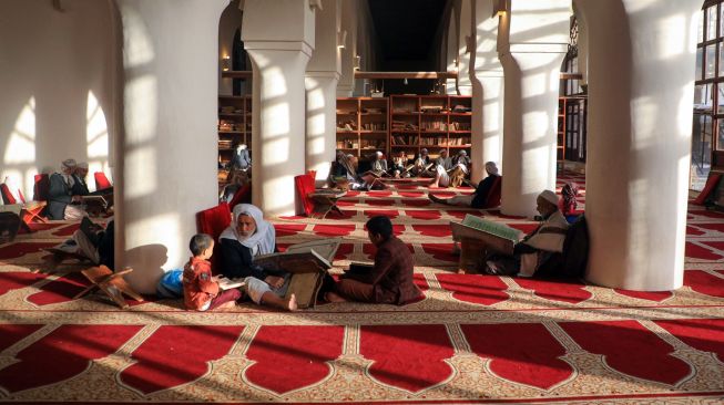 Anak-anak membaca Alquran di Masjid Al-Kabir, Sana'a, Yaman, Sabtu (2/4/2022). [MOHAMMED HUWAIS / AFP]