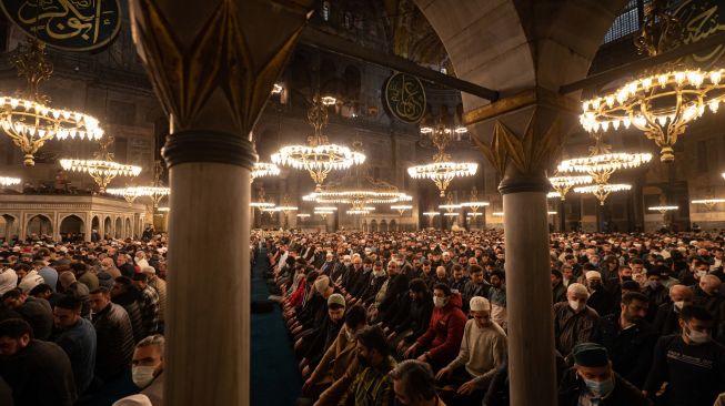 Umat Muslim melaksanakan ibadah shalat Tarawih di Masjid Hagia Sophia, Istanbul, Turki, Sabtu (1/4/2022). [Yasin AKGUL/AFP]