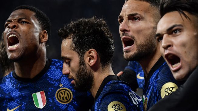 Gelandang Inter Milan Hakan Calhanoglu (tengah) berselebrasi dengan bek Inter Milan Denzel Dumfries, bek Inter Milan Danilo D'Ambrosio dan pemain depan Inter Milan Lautaro Martinez setelah mencetak gol lewat titik putih saat pertandingan sepak bola Serie A Italia antara Juventus dan Inter di Stadion Allianz, Turin, Italia, Minggu (3/4/2022). [Filippo MONTEFORTE / AFP]