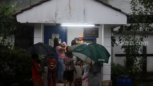 Warga berteduh saat mengantre untuk mendapatkan takjil gratis di Jalan Cempaka Putih Tengah XXI, Jakarta, Selasa (5/4/2022). [Suara.com/Angga Budhiyanto]