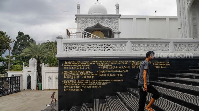 Terjemahan Surat Al-Fatihah terlihat dalam bahasa Inggris, Bahasa Indonesia dan aksara China di dinding Masjid Ramlie Musofa di Sunter, Jakarta Utara, Selasa (5/4/2022). [Suara.com/Alfian Winanto]