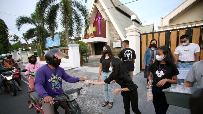 Pemuda Kristen membagikan takjil kepada pengguna jalan di Blitar, Jawa Timur, Kamis (7/4/2022).  ANTARA FOTO/Irfan Anshorihp