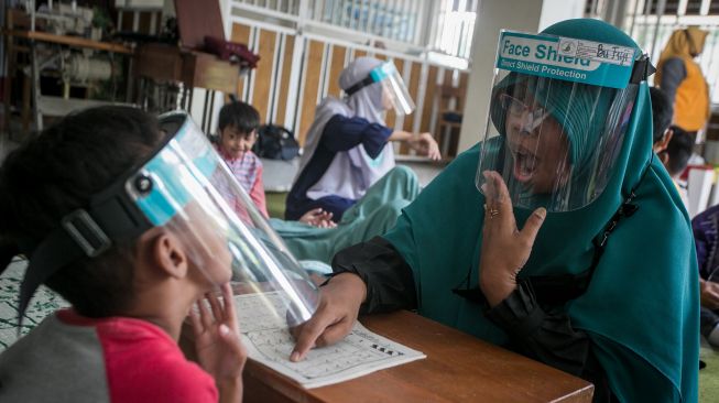 Guru mengajari siswa penyandang tuna rungu membaca Iqra dengan metode membaca gerak bibir saat mengikuti kegiatan Pesantren Kilat Ramadhan Tuna Rungu di SLB B Prawestri, Karanganyar, Jawa Tengah, Kamis (7/4/2022).  ANTARA FOTO/Mohammad Ayudha
