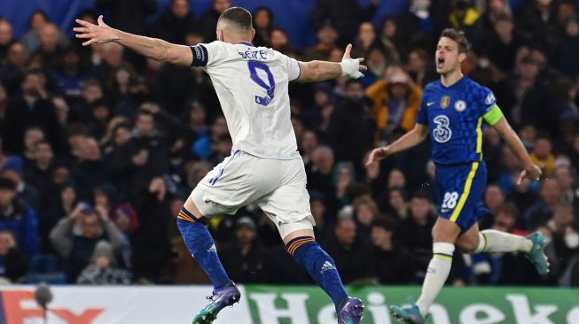 Striker Real Madrid Karim Benzema merayakan golnya setelah mencetak gol keduanya pada pertandingan sepak bola leg pertama Perempat final Liga Champions UEFA antara Chelsea melawan Real Madrid di Stadion Stamford Bridge, Kamis (7/4) dini hari WIB. JAVIER SORIANO / AFP
