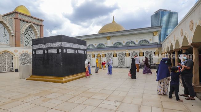 Warga berwisata Ramadhan melihat miniatur Ka'bah di Masjid Nurul Iman, Blok M Square, Jakarta Selatan, Jumat (8/4/2022). [Suara.com/Alfian Winanto]