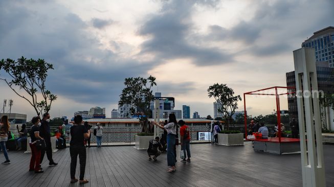 Warga berwisata akhir pekan sambil ngabuburit di Sky Deck Pusat Perbelanjaan Sarinah, Jakarta Pusat, Sabtu (9/4/2022). [Suara.com/Alfian Winanto]