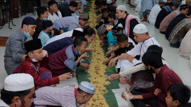 Umat Islam menggelar makan bersama atau megibung saat berbuka puasa di Masjid Baitul Makmur, Denpasar, Bali, Jumat (8/4/2022). [ANTARA FOTO/Nyoman Hendra Wibowo/wsj]
