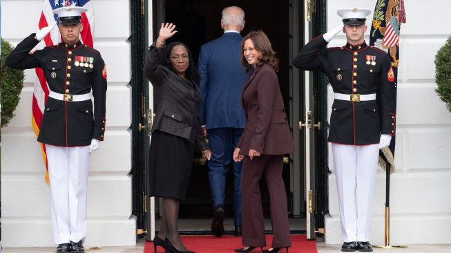 Hakim Ketanji Brown Jackson melambaikan tangan saat dia berjalan kembali kedalam Gedung Putih bersama presiden Amerika Serikat Joe Biden dan Wakil Presiden Kamala Harris setelah acara pengukuhan Jackson menjadi Hakim Agung Amerika Serikat di Gedung Putih, Washington DC, Amerika Serikat, Jumat (8/4/2022). [Jim WATSON / AFP]