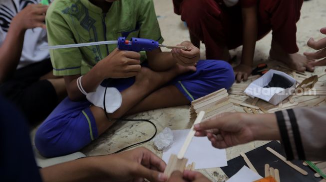 Peserta membuat kerajinan tangan saat mengikuti kegiatan Pesantren Kilat Ramadhan di Masjid Agung Sunda Kelapa, Menteng, Jakarta, Minggu (10/4/2022). [Suara.com/Angga Budhiyanto]