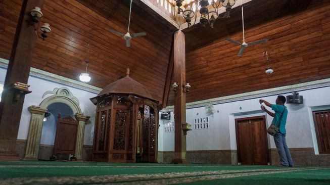 Pengunjung mengabadikan gambar ruangan dalam masjid menggunakan telepon selulernya di Masjid Jami Aulia, Sapuro, Pekalongan, Jawa Tengah, Sabtu (9/4/2022).  ANTARA FOTO/Harviyan Perdana Putra