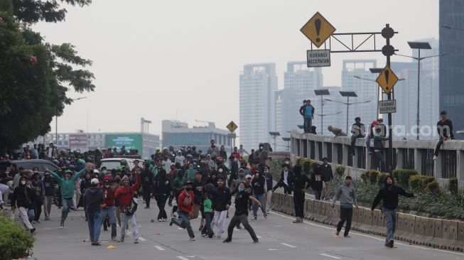 Massa aksi terlibat kericuhan dengan polisi saat unjuk rasa di sekitar gedung DPR RI, Jakarta, Senin (11/4/2022). [Suara.com/Angga Budhiyanto]