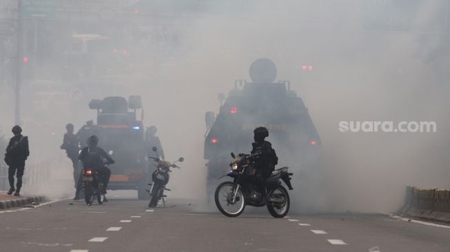 Polisi membubarkan massa aksi saat unjuk rasa di sekitar gedung DPR RI, Jakarta, Senin (11/4/2022). [Suara.com/Angga Budhiyanto]