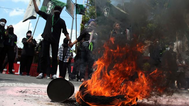 Mahasiswa melakukan aksi bakar ban bekas di depan kantor DPRD Kota Blitar, Jawa Timur, Senin (11/4/2022).  ANTARA FOTO/Irfan Anshori