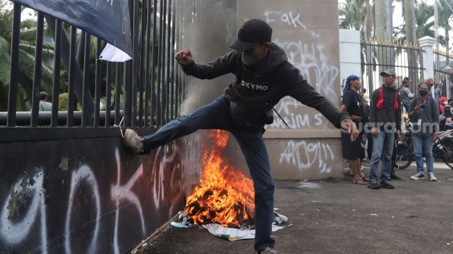 Massa aksi menendang gerbang saat melakukan unjuk rasa di depan gedung DPR RI, Jakarta, Senin (11/4/2022). [Suara.com/Angga Budhiyanto]