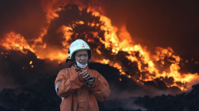 Petugas Dinas Pemadam Kebakaran Kota Surabaya memadamkan gudang yang terbakar di kawasan Pergudangan Margomulyo Permai, Surabaya, Jawa Timur, Selasa (12/4/2022).  ANTARA FOTO/Didik Suhartono
