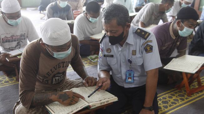 Sejumlah narapidana belajar membaca Al Quran saat pesantren kilat di Masjid An-Nur kompleks Rutan Kelas 1A Solo, Jawa Tengah, Senin (11/4/2022). .ANTARAFOTO/Maulana Surya