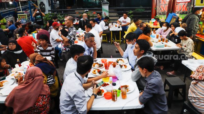 Suasana saat berbuka puasa di Sentra kuliner Nasi Kapau di Jalan Kramat Raya, Senen, Jakarta Pusat, Selasa (12/4/2021). [Suara.com/Alfian Winanto]