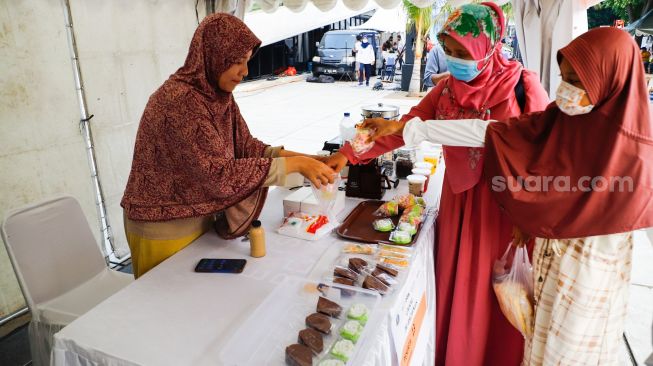 Pengunjung membeli makanan di acara Festival Kuliner Nusantara di Taman Ismail Marzuki (TIM), Cikini, Jakarta Pusat, Rabu (13/4/2022). [Suara.com/Alfian Winanto]