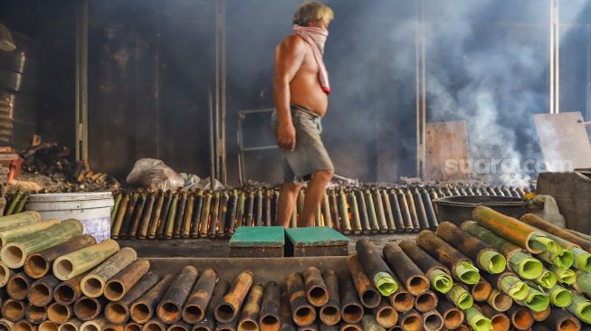 Pekerja menyelesaikan pembuatan lemang bambu di Kramat Raya, Senen, Jakarta Pusat, Rabu (13/4/2022). [Suara.com/Alfian Winanto]