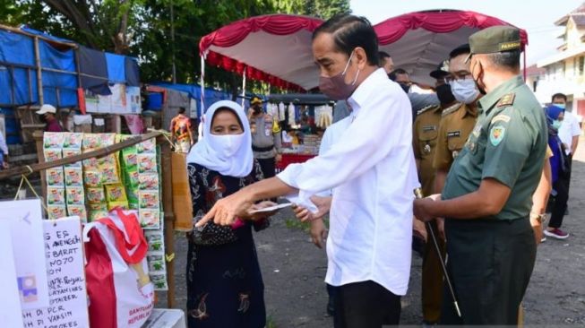 Presiden Joko Widodo memberikan sejumlah bantuan sosial (bansos) di Pasar Harjamukti, Kota Cirebon, Jawa Barat, Rabu, (13/4). (Biro Pers Sekretariat Presiden/Muchlis Jr)