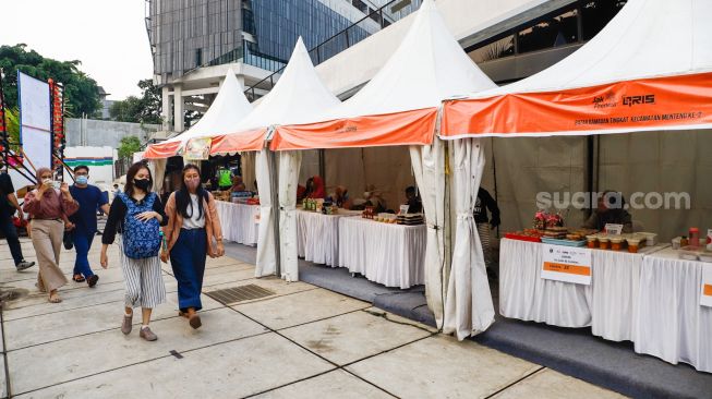 Pengunjung membeli makanan di acara Festival Kuliner Nusantara di Taman Ismail Marzuki (TIM), Cikini, Jakarta Pusat, Rabu (13/4/2022). [Suara.com/Alfian Winanto]