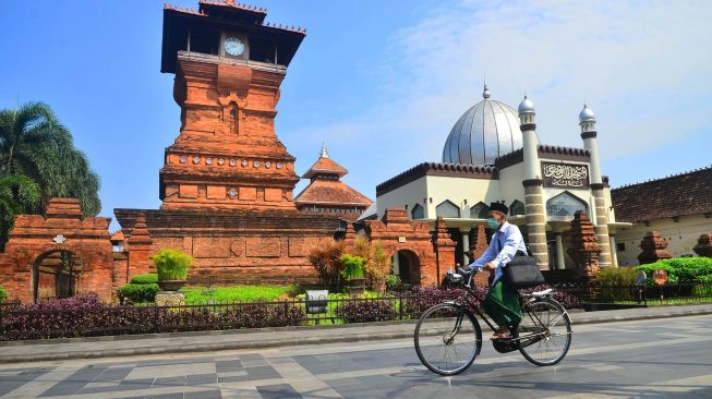 Warga melintas di depan Masjid Menara Kudus atau bernama resmi Masjid Al Aqsa Manarat Qudus di Desa Kauman, Kudus, Jawa Tengah, Rabu (13/4/2022).  ANTARA FOTO/Yusuf Nugroho
