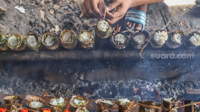 Pekerja menyelesaikan pembuatan lemang bambu di Kramat Raya, Senen, Jakarta Pusat, Rabu (13/4/2022). [Suara.com/Alfian Winanto]