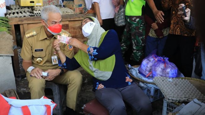 Gubernur Jawa Tengah Ganjar Pranowo saat bersama pedagang telur asin di Brebes. [Dok Pemprov Jateng]