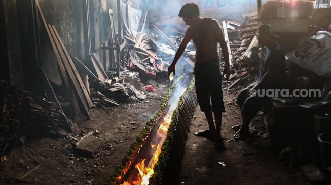 Pekerja menyelesaikan pembuatan lemang bambu di Kramat Raya, Senen, Jakarta Pusat, Rabu (13/4/2022). [Suara.com/Alfian Winanto]