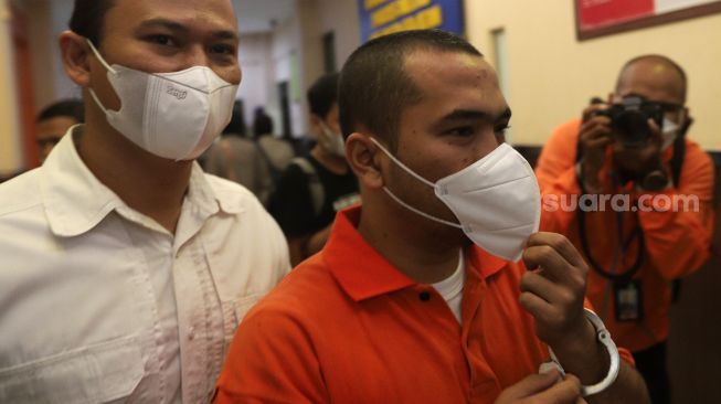 Tersangka pengeroyokan yang juga pengusaha pemilik gerai penjualan gawai, Putra Siregar (kanan) dihadirkan saat rilis kasus di Polres Metro Jakarta Selatan, Rabu (13/4/2022). [Suara.com/Angga Budhiyanto]