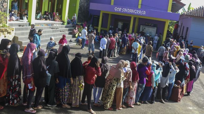 Sejumlah warga antre untuk mendapatkan Bantuan Langsung Tunai (BLT) minyak di GOR Kelurahan Sindangrasa, Kabupaten Ciamis, Jawa Barat, Kamis (14/4/2022). ANTARA FOTO/Adeng Bustomi
