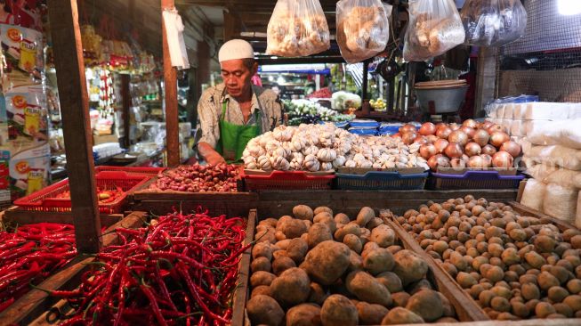 Pedagang menunggu pembeli di Pasar PSPT Tebet, Jakarta Selatan, Kamis (14/4/2022). [Suara.com/Alfian Winanto]