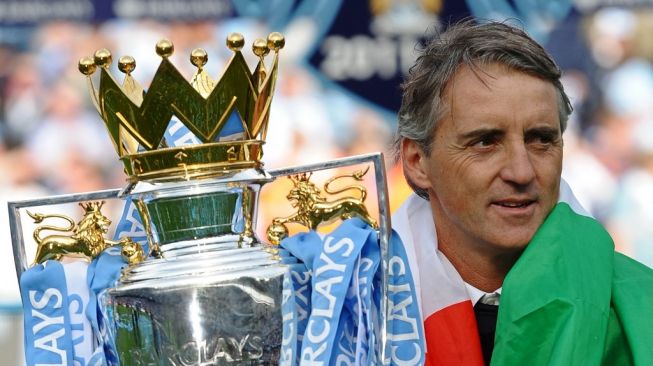 Manajer Manchester City asal Italia Roberto Mancini mengangkat trofi Liga Inggris di lapangan setelah kemenangan 3-2 mereka atas Queens Park Rangers dalam laga terakhir Liga Inggris antara Manchester City vs Queens Park Rangers di stadion Etihad pada 13 Mei 2012. Manchester City memenangkan pertandingan 3-2 untuk mengamankan gelar pertama mereka sejak 1968. Ini adalah pertama kalinya gelar Liga Premier ditentukan dengan selisih gol, Manchester City dan Manchester United sama-sama finis dengan 89 poin . AFP PHOTO/PAUL ELLIS