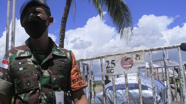 Seorang anggkota TNI AU mengawasi proses pengakutan peti mati berisi jenazah korban kecelakaan maut di Papua Barat tiba di bandara El Tari Kupang, NTT, Kamis (14/4/2022). ANTARA FOTO/Kornelis Kaha