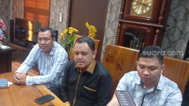 Ade Armando's attorney, Aulia Fahmi (center) holding a press conference in Kebayoran Baru, South Jakarta.  (Suara.com/Arga)