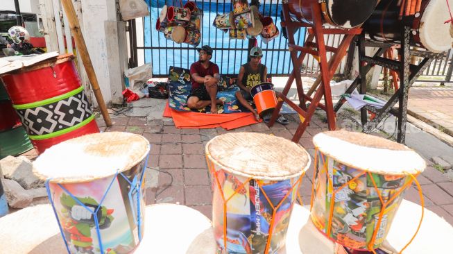 Penjual bedug menunggu pembeli di Jalan KH Mas Mansyur, Tanah Abang, Jakarta Pusat, Jumat (15/4/2022). [Suara.com/Alfian Winanto]